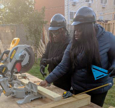 Two BCJC trainees are working together to use a circular saw
